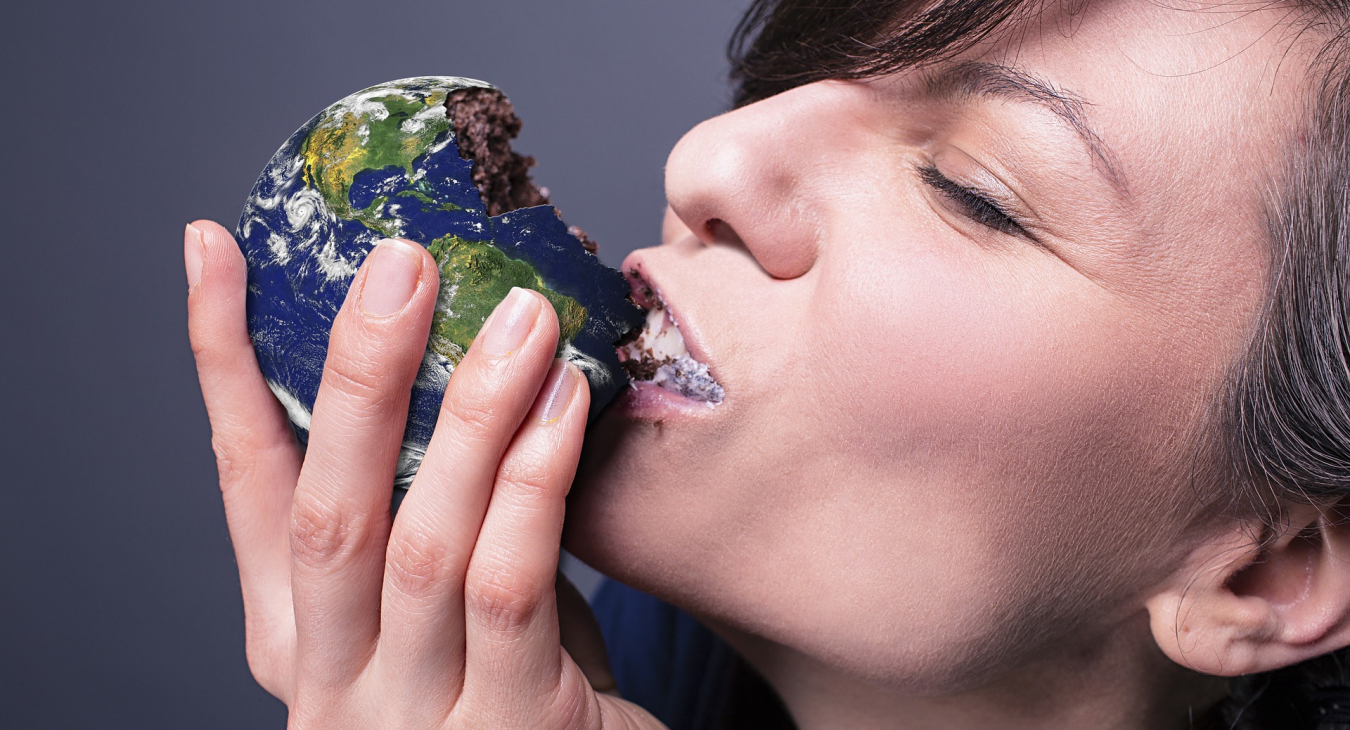 Een vrouw eet taart in de vorm van een wereldbol