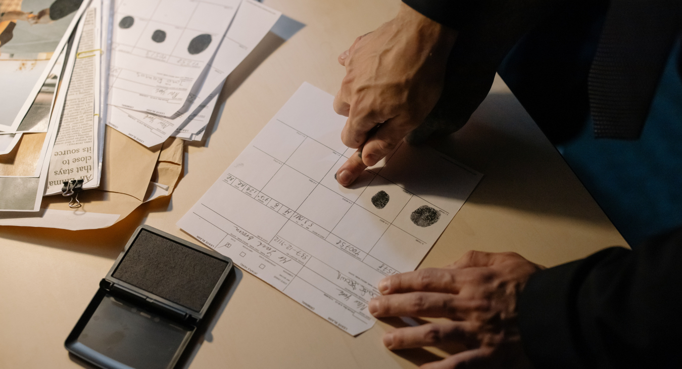 Twee handen stempelen vingerafdrukken op politiebureau